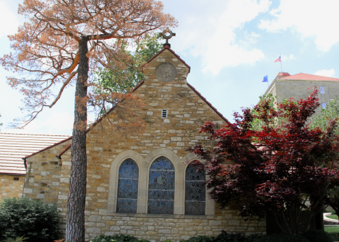 Danforth Chapel's North side including the cross, 3 stained glass windows, and Fraser Hall to the right side