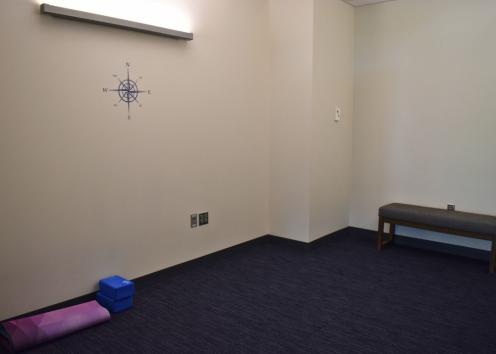A small room used for personal reflection. Includes cardinal directions, a bench, yoga mat and yoga blocks. 