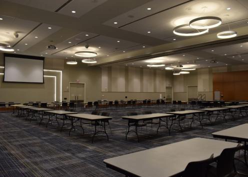 Forums C and D combined with multiple 6 foot tables with 2 chairs spaced around the room for a tabling fair