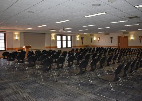 Big 12 room with theater seating towards the monitor and podium